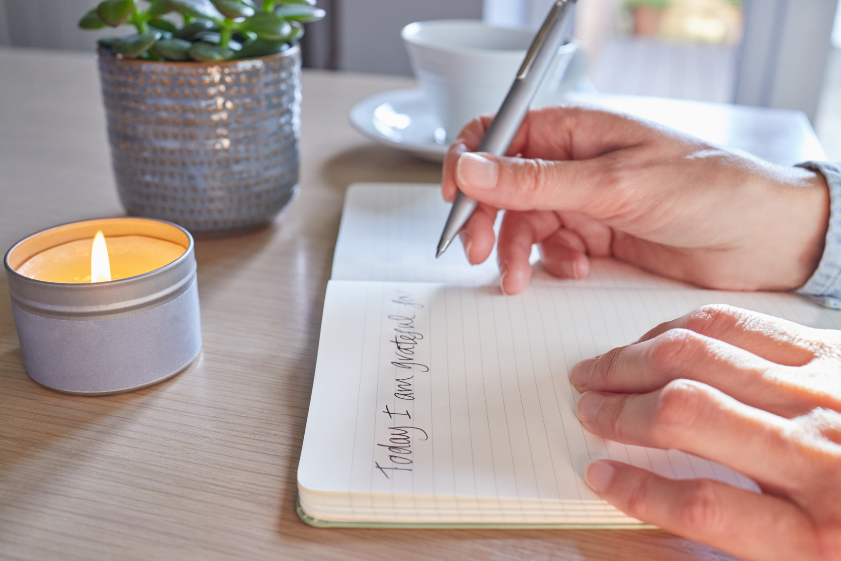 Close Up Of Woman At Home Writing In Gratitude Journal